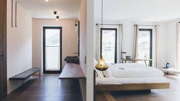 Un dormitorio moderno con una cama grande, mesita de noche y vistas al exterior.