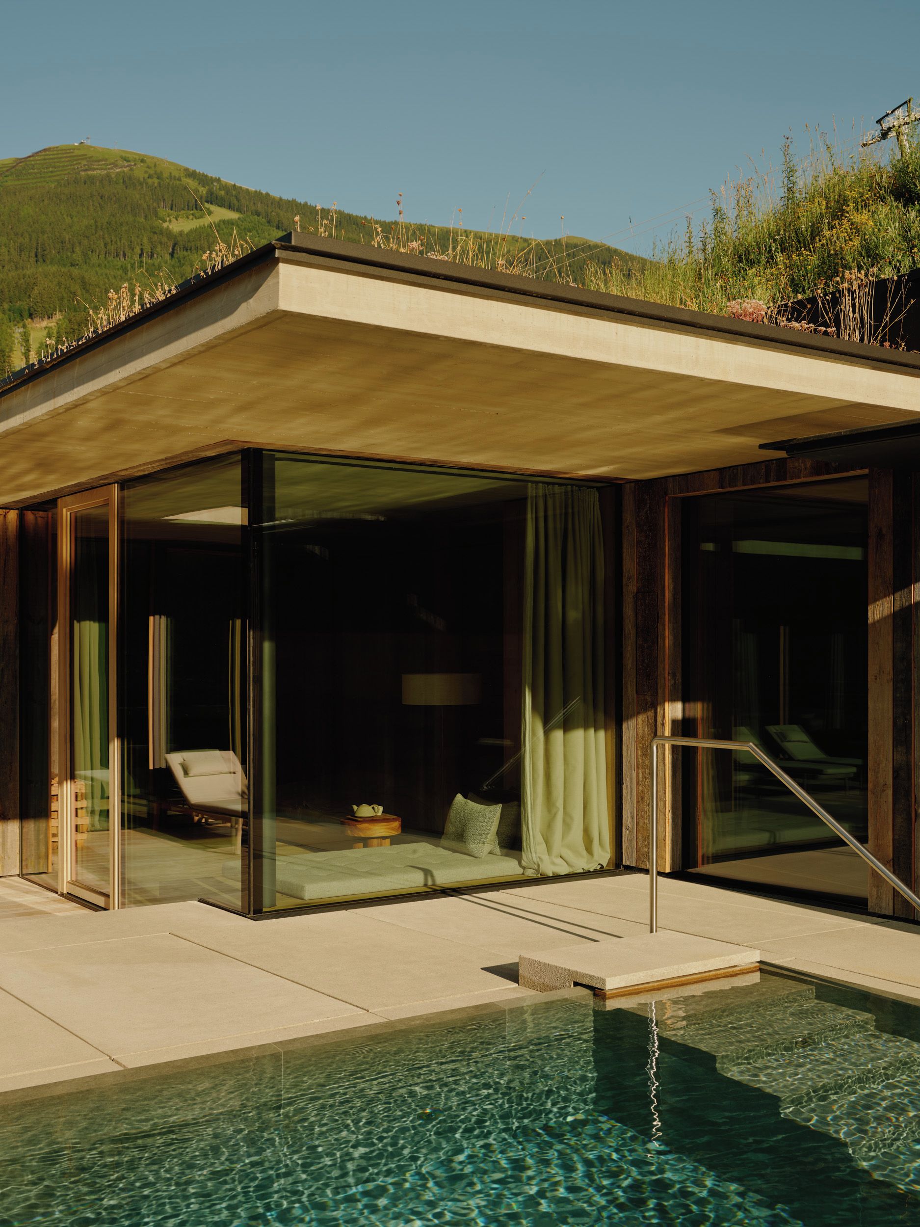 A modern house with a glass-enclosed patio and a swimming pool.