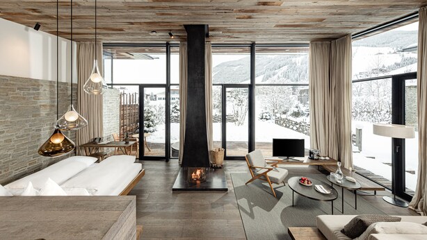 A modern interior with a fireplace, large windows, and a cozy seating area. - Wiesergut (Saalbach-Hinterglemm)