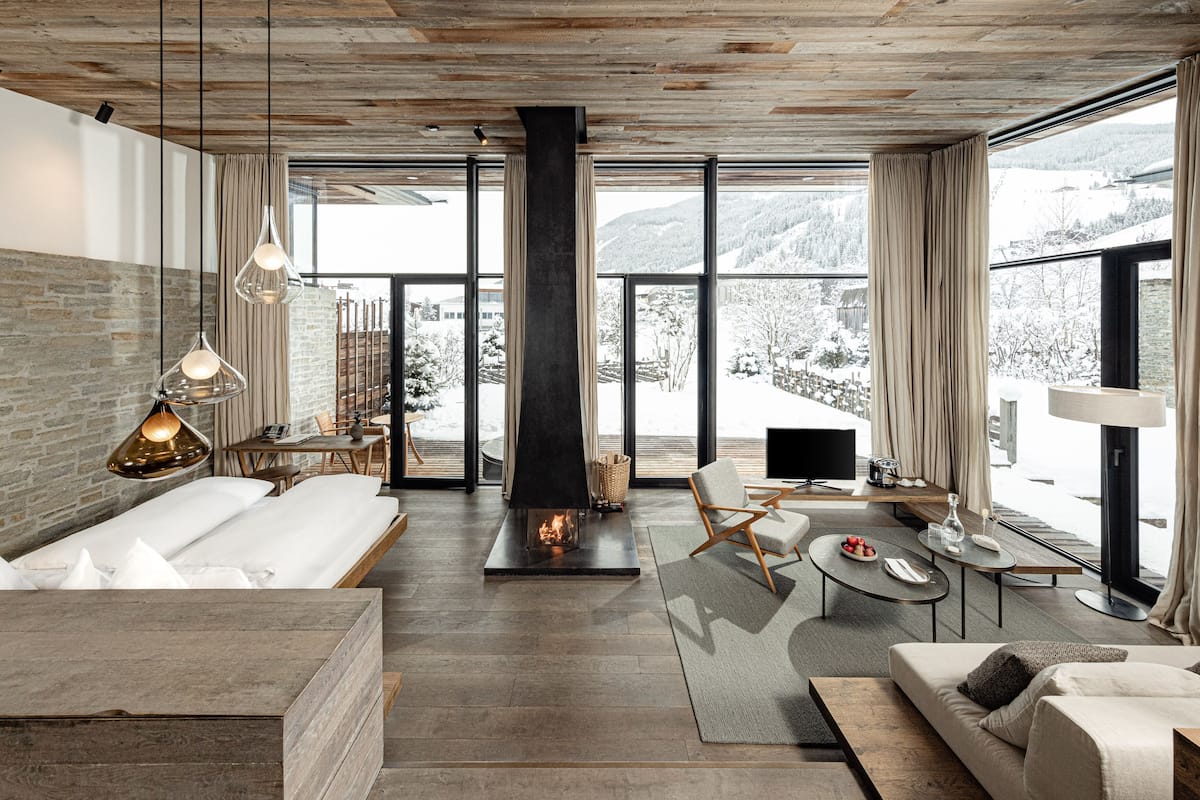 A modern interior with a fireplace, large windows, and a cozy seating area.