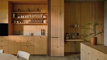 Una cocina moderna con armarios de madera, una isla central y una planta en maceta.