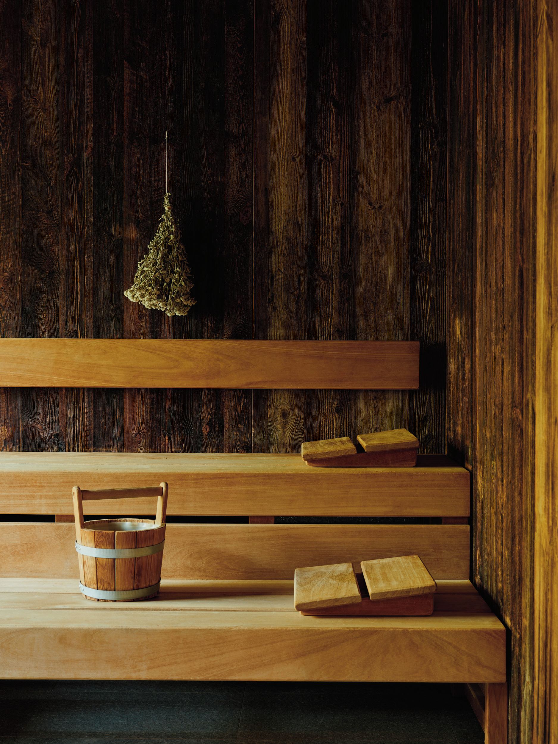 Un banco de madera con una cesta tejida y un libro.