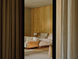A bedroom with a bed, a nightstand, and a lamp.