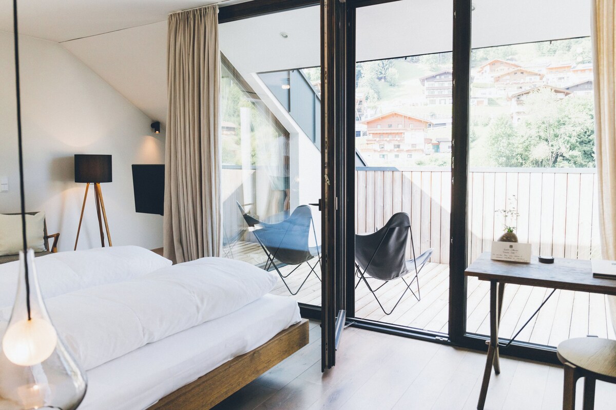 A modern bedroom with a bed, a desk, and a chair.