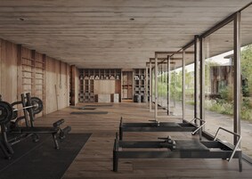 Un gimnasio moderno con suelo de madera, equipamiento de levantamiento de pesas y amplias ventanas con vistas al exterior.