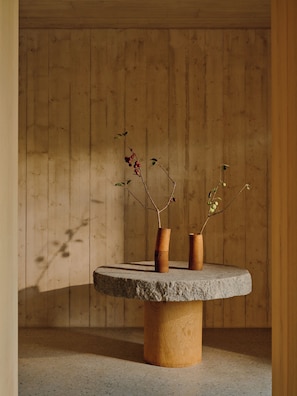 A round stone table with two wooden vases against a wooden wall. - Wiesergut (Saalbach-Hinterglemm)