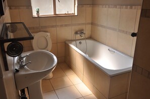 Un baño con inodoro, lavabo y bañera.