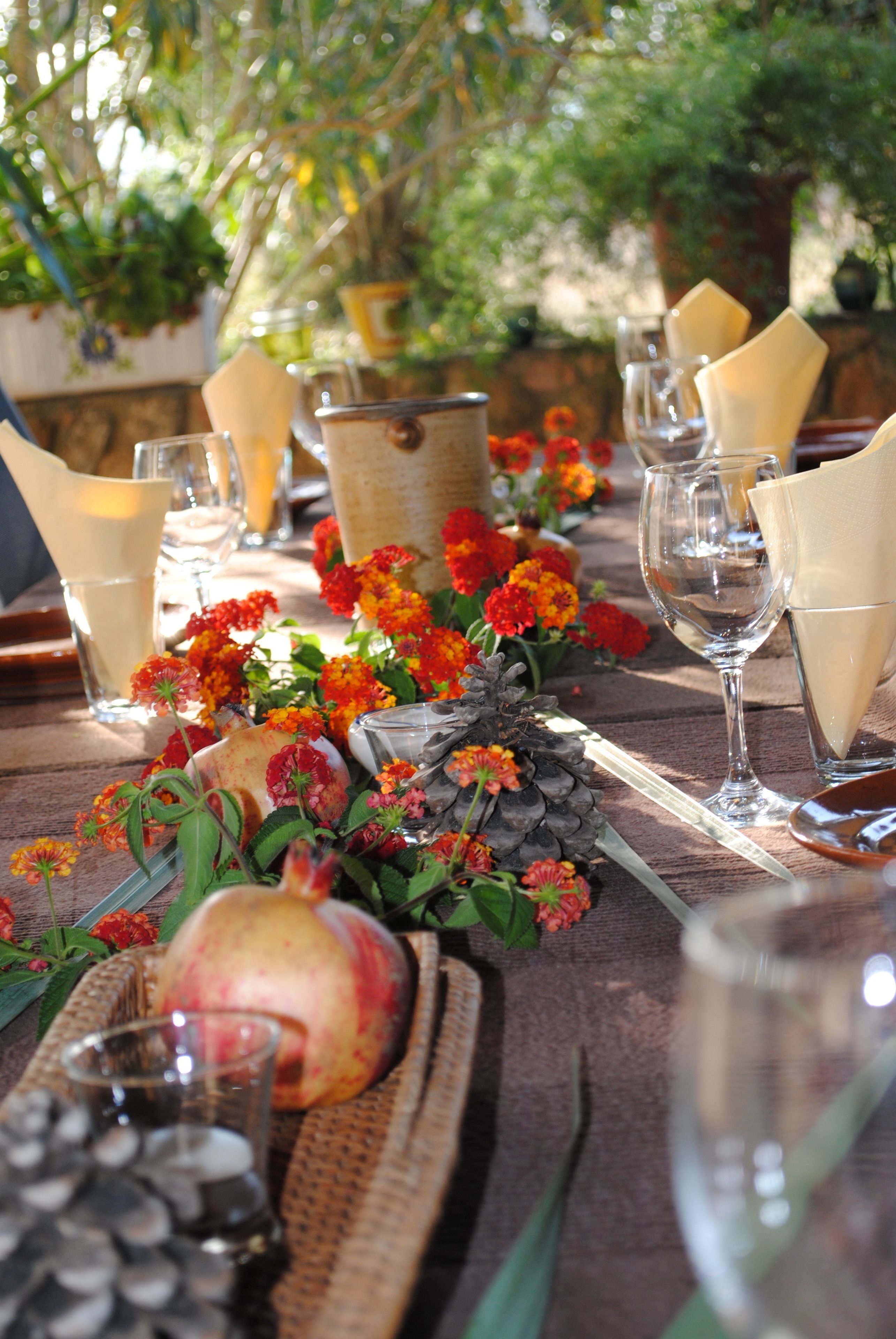 A table set with glassware, napkins, and a fruit centerpiece.