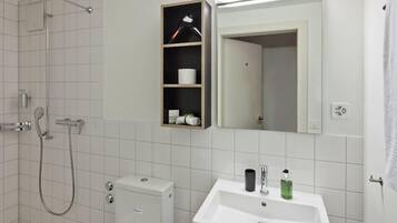 Une salle de bain moderne équipée d’une douche, de toilettes et d’un lavabo.