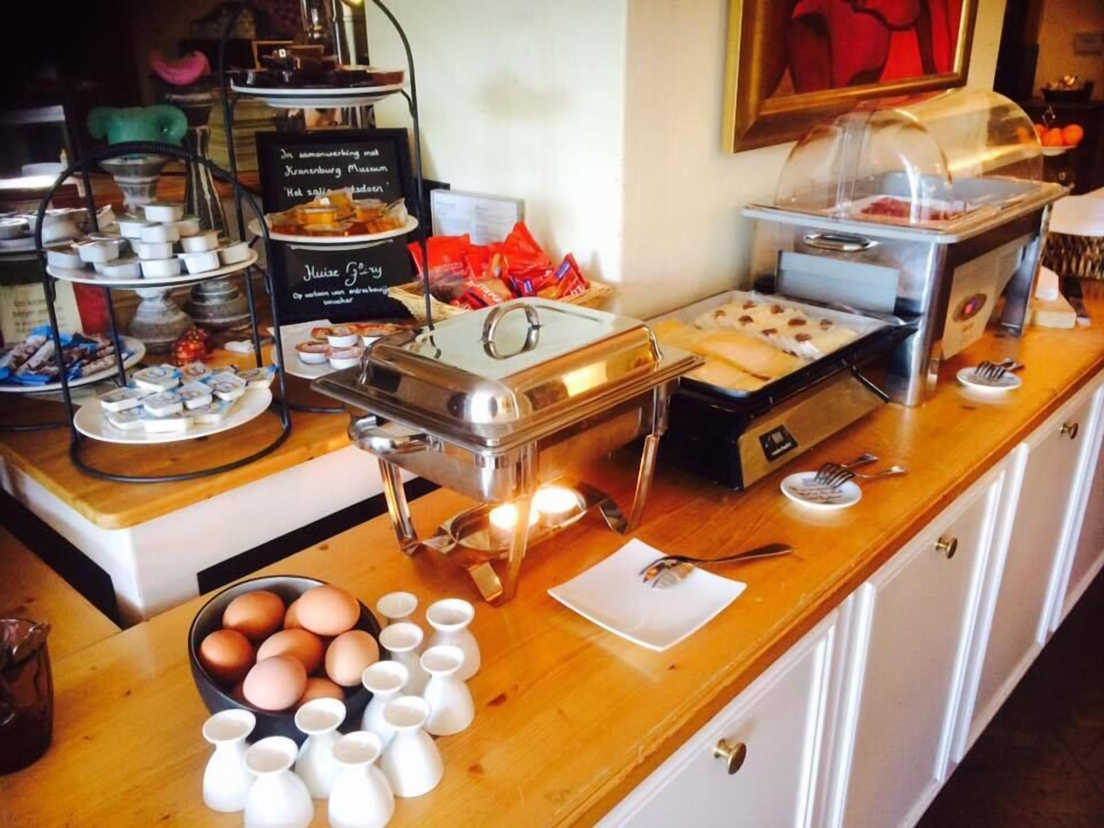 A buffet setup with various food items and serving utensils.
