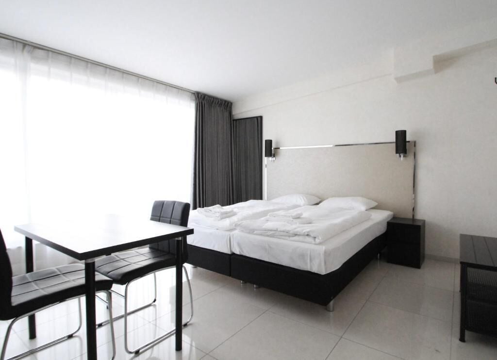 Una habitación de hotel moderna con una cama, un escritorio y una silla.