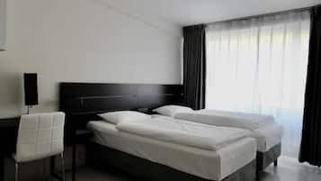 Une chambre d’hôtel moderne avec un grand lit, un bureau et une chaise.