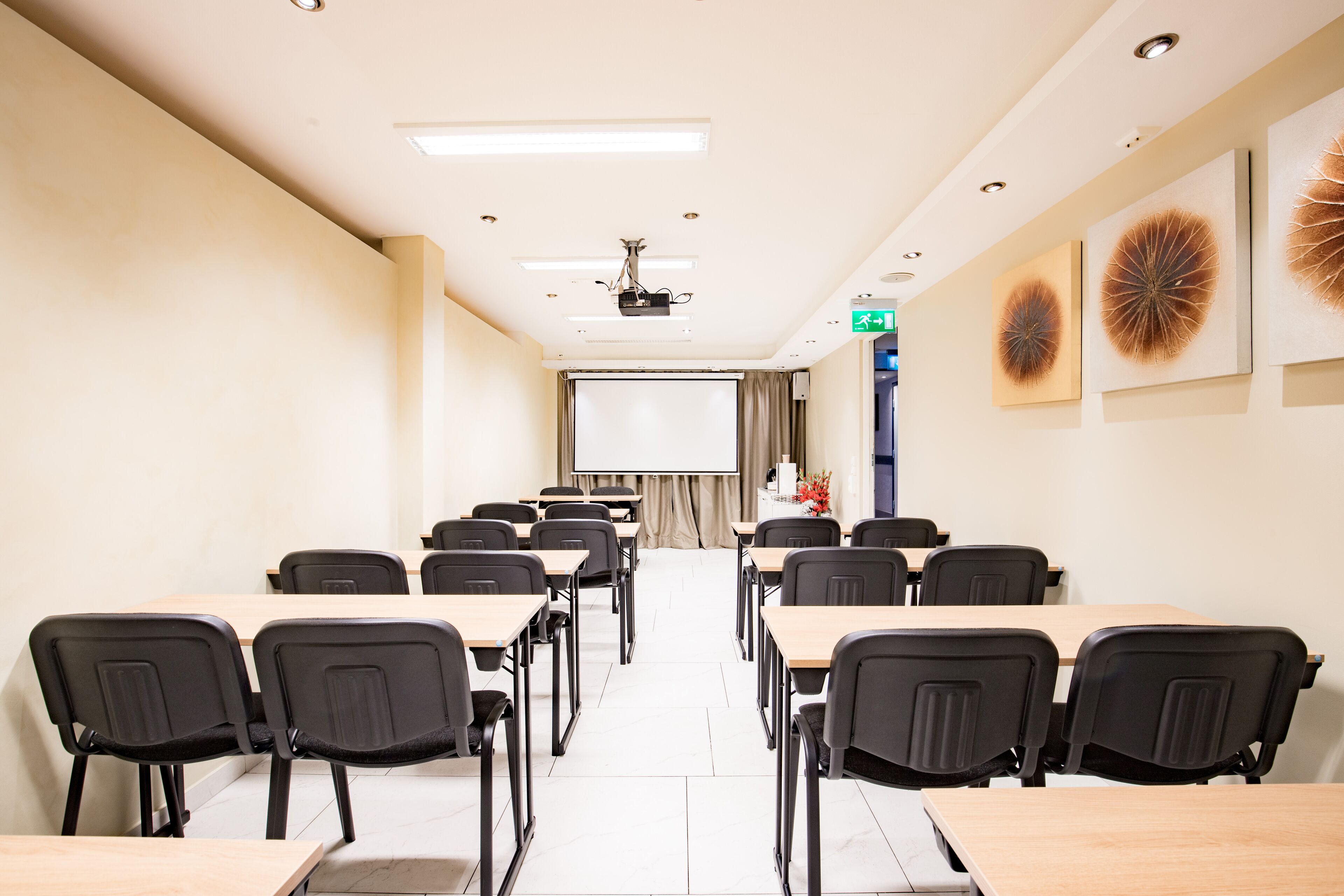 A conference room with a projector screen, a whiteboard, and a projector.