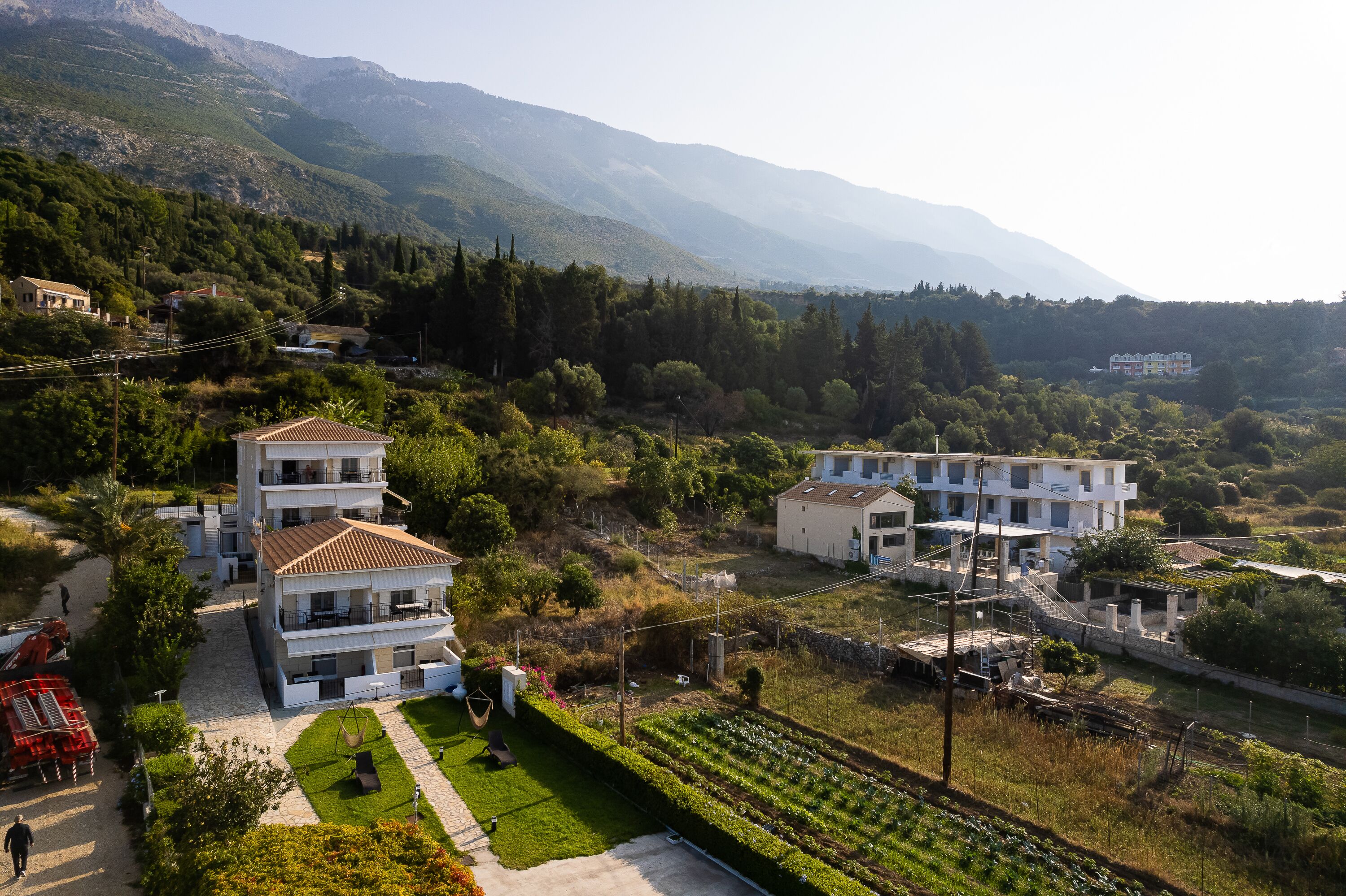 A multi-story building with a garden and a view of the surrounding landscape.