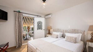Un dormitorio con cama, mesitas de noche, lámpara y vistas al exterior.