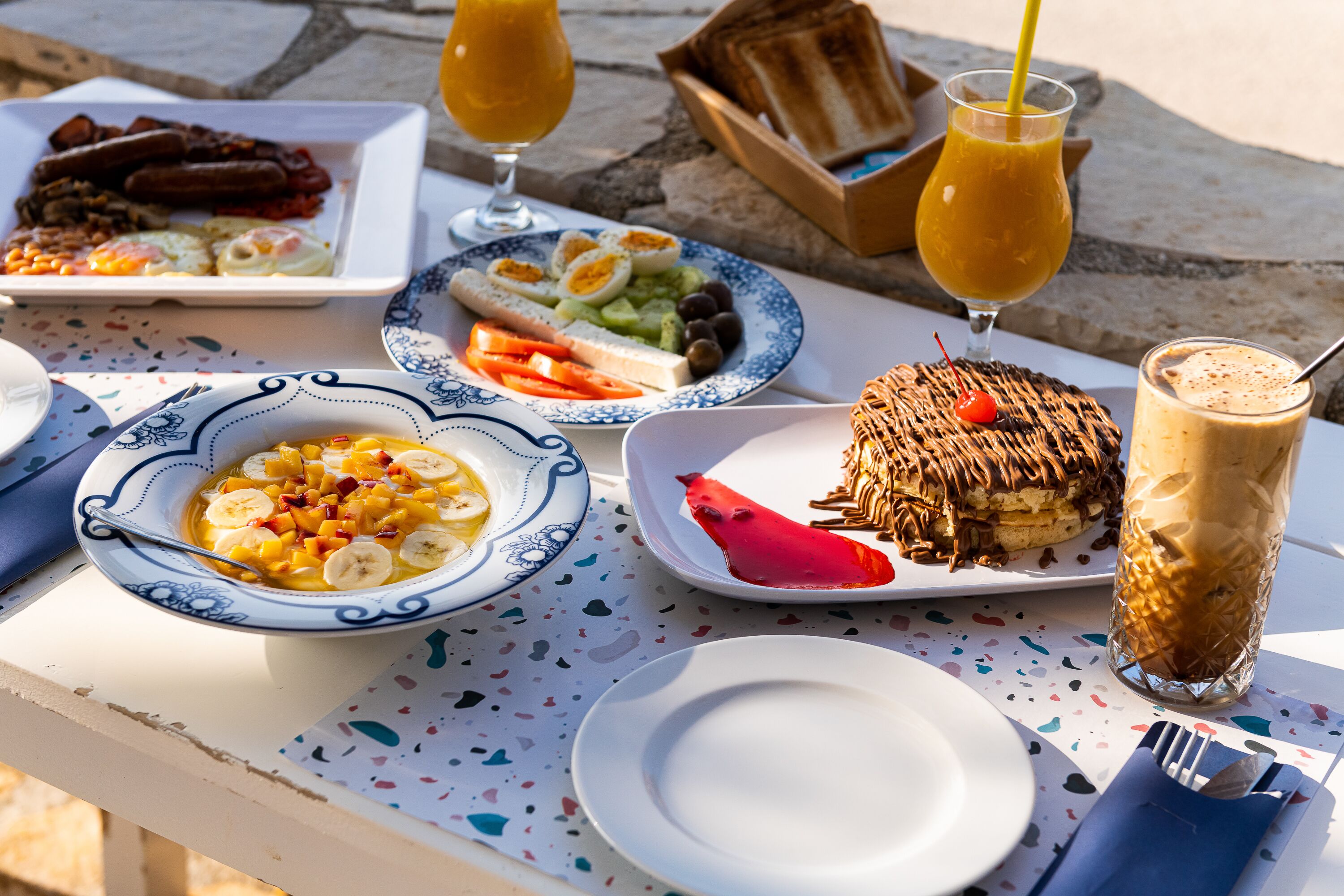 Une table dressée avec des aliments pour le petit-déjeuner, notamment des œufs, des toasts et un panier de fruits.