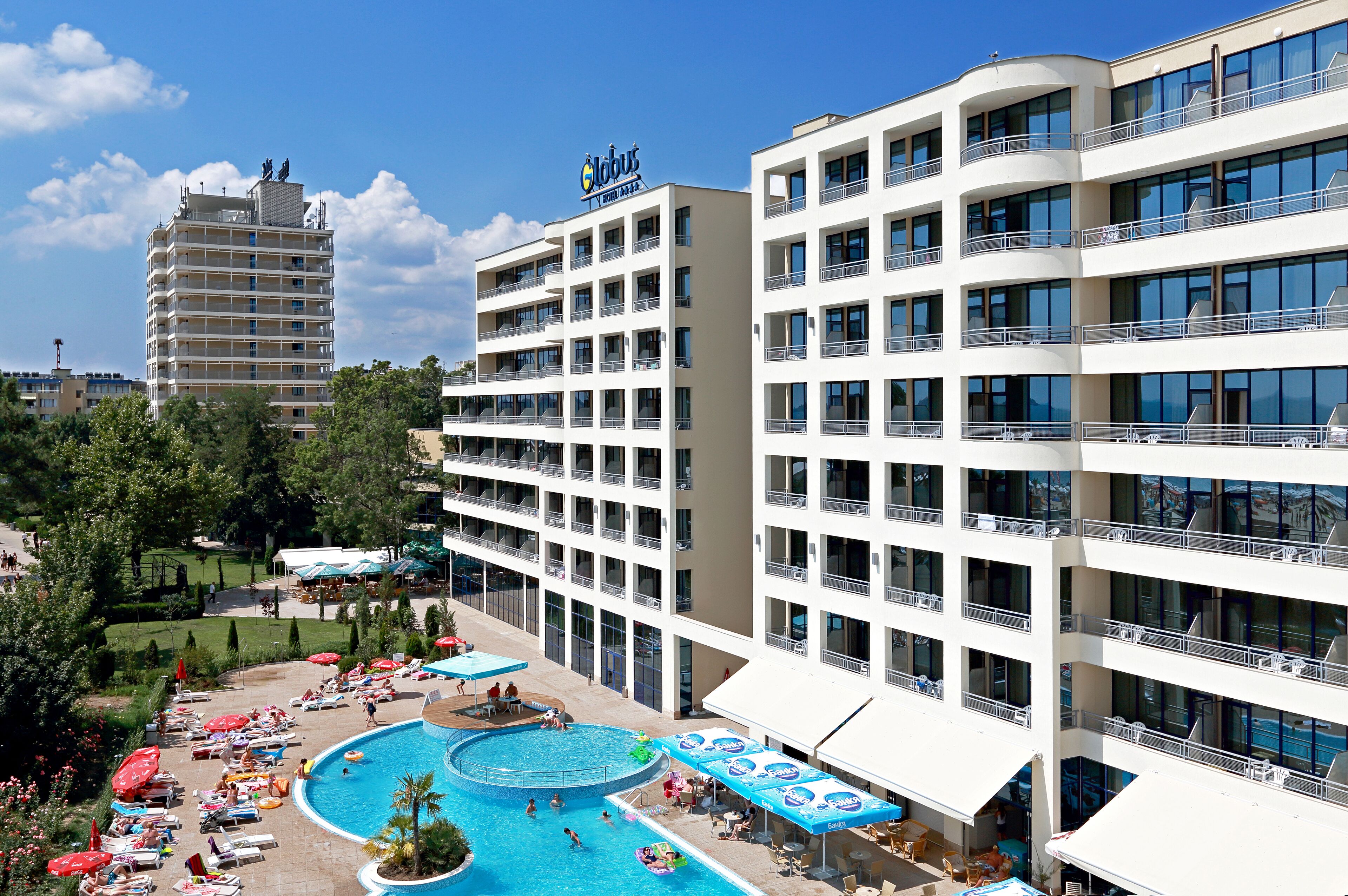 A hotel with multiple floors, a swimming pool, and outdoor seating areas.