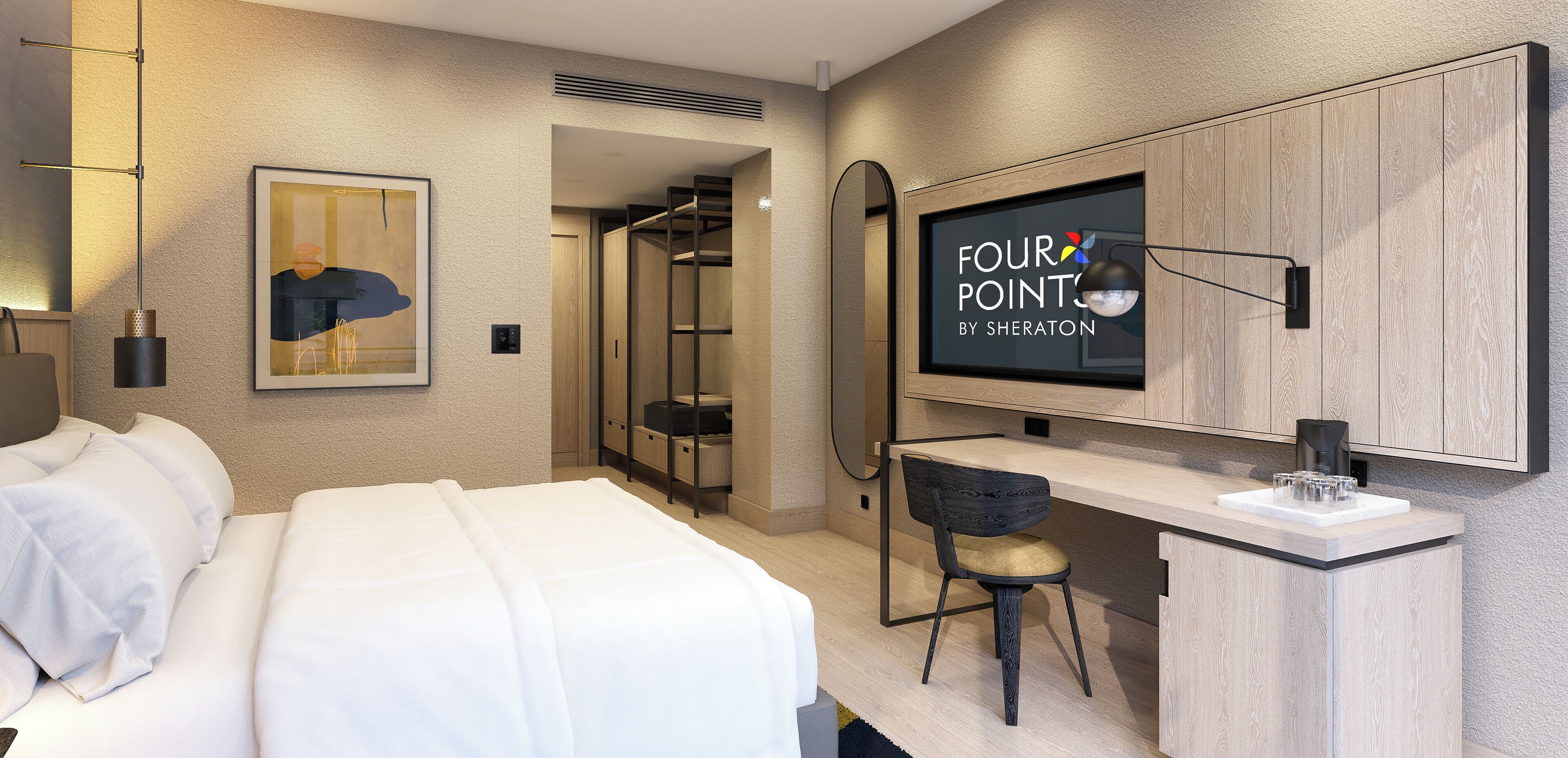 Une chambre d’hôtel moderne équipée d’un lit, d’un bureau avec une chaise, d’un grand miroir et d’un téléviseur affichant le logo « FOUR POINTS BY SHERATON ».