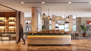 A modern interior with a central island featuring multiple bowls, a seating area with a table and chairs, and a decorative wall with framed artwork. - Four Points by Sheraton Sunny Beach (Sunny Beach)