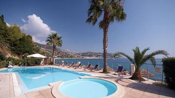 Piscine extérieure, parasols de plage, chaises longues