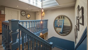 A staircase with blue railings and a skylight above.