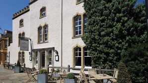 A building with a sign reading "Townhouse" and outdoor seating with tables and chairs.