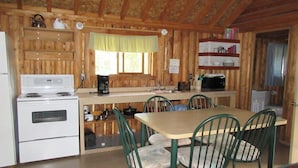 A compact kitchen with a stove, sink, and dining area.