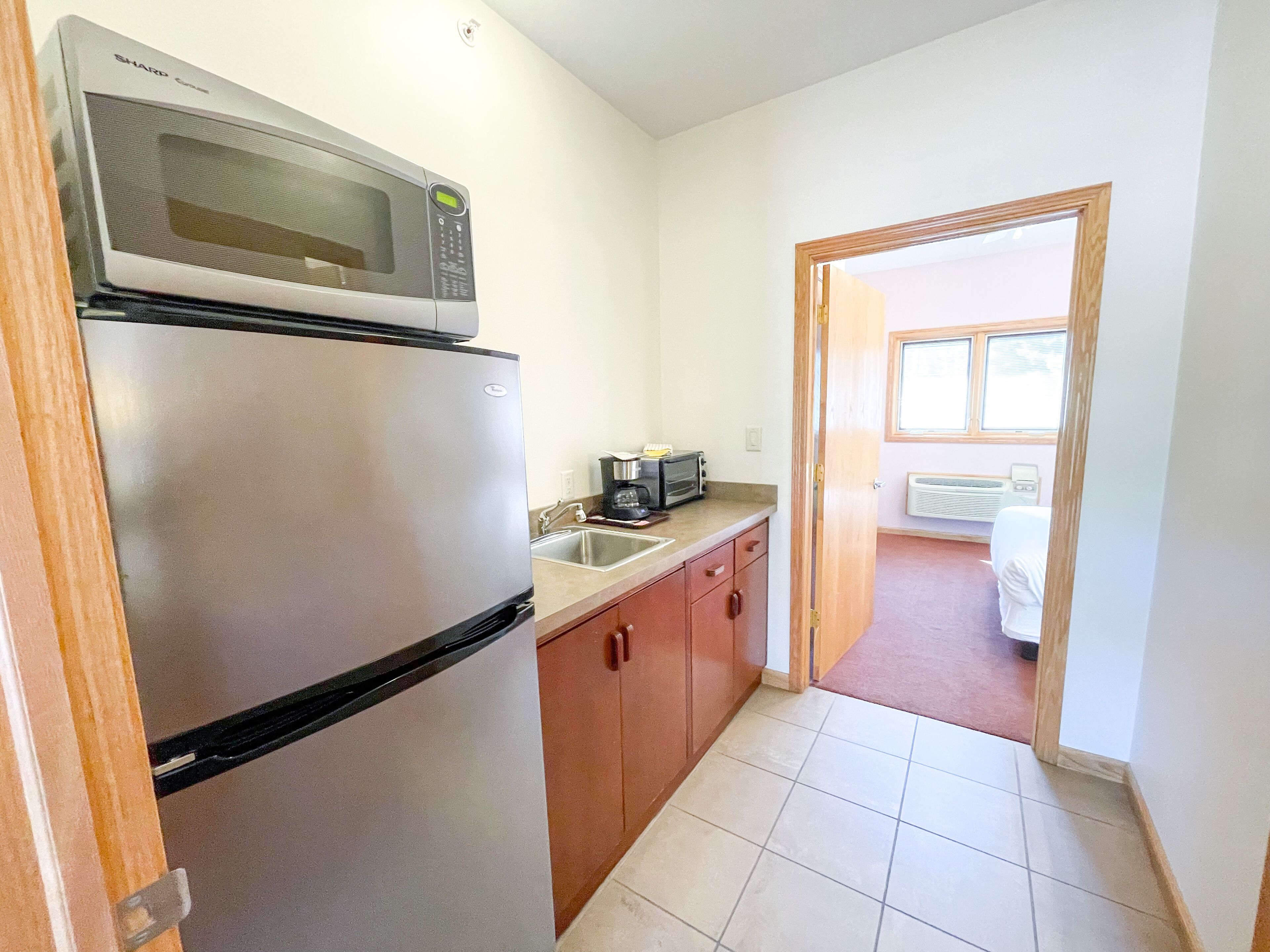 A compact kitchen with a refrigerator, microwave, and a toaster.