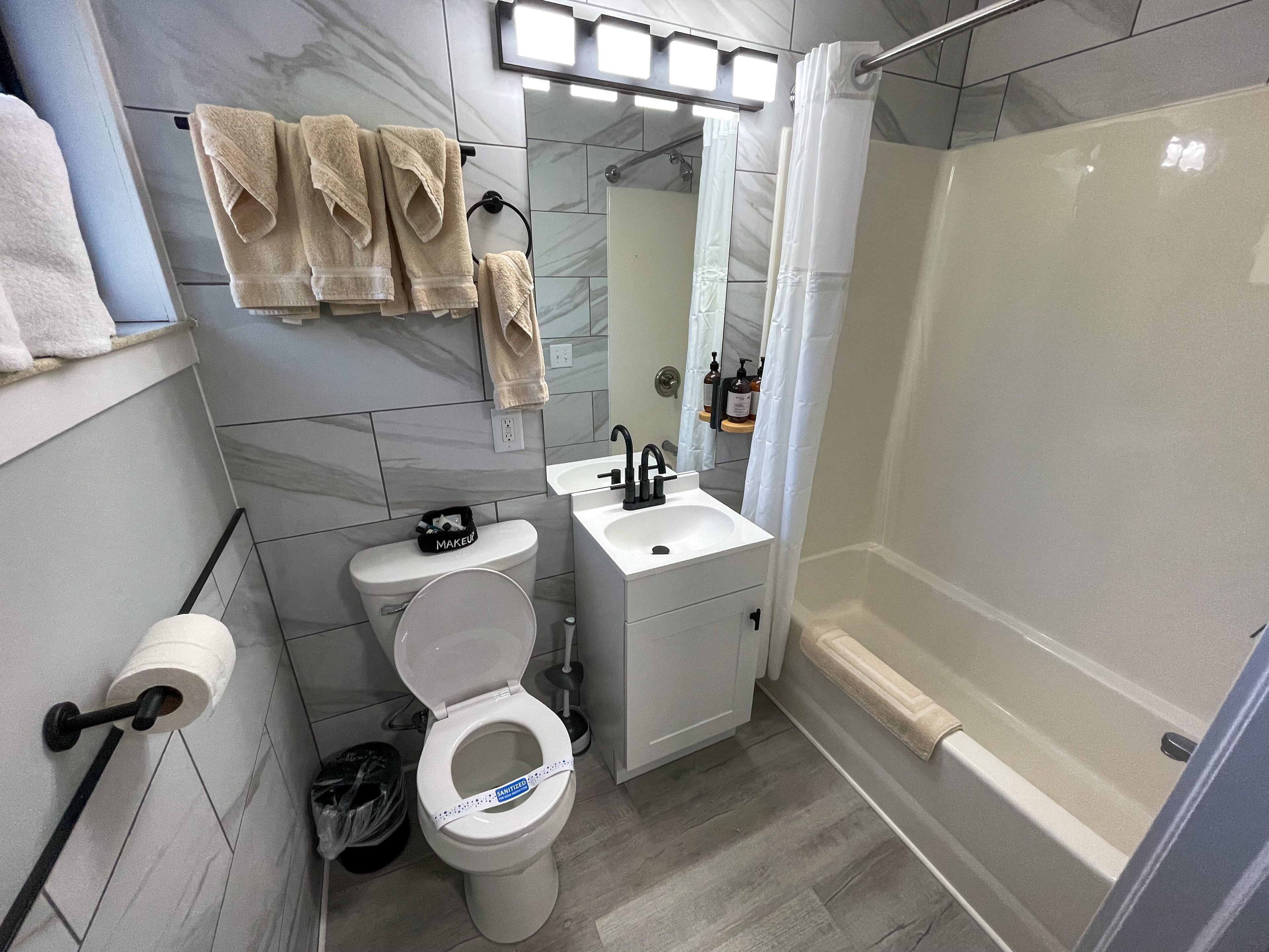 Un baño moderno con inodoro, lavamanos y ducha.