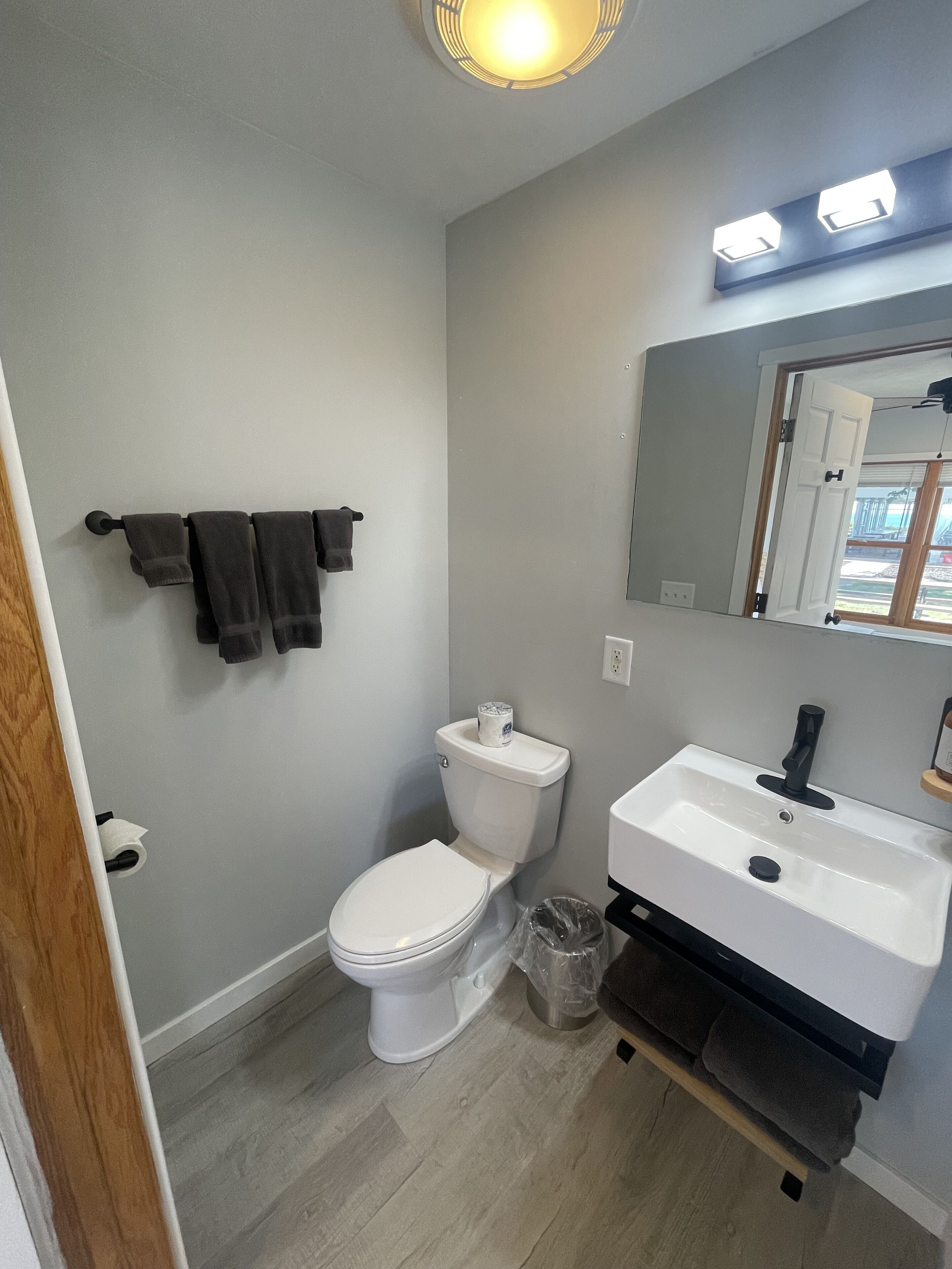 A bathroom with a toilet, sink, and a towel rack.
