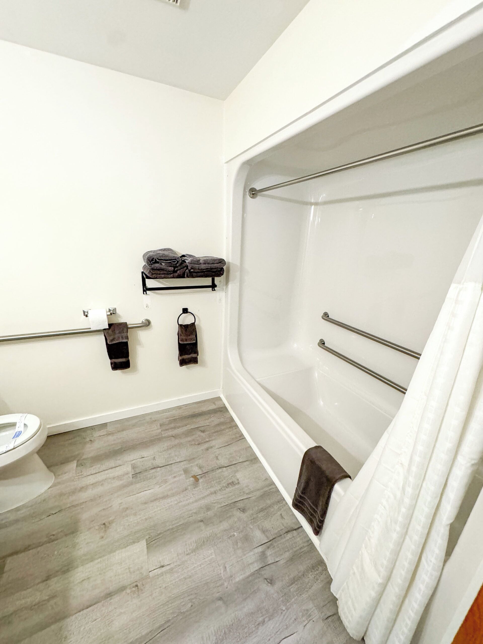 Un baño con bañera, inodoro y un perchero para toallas.