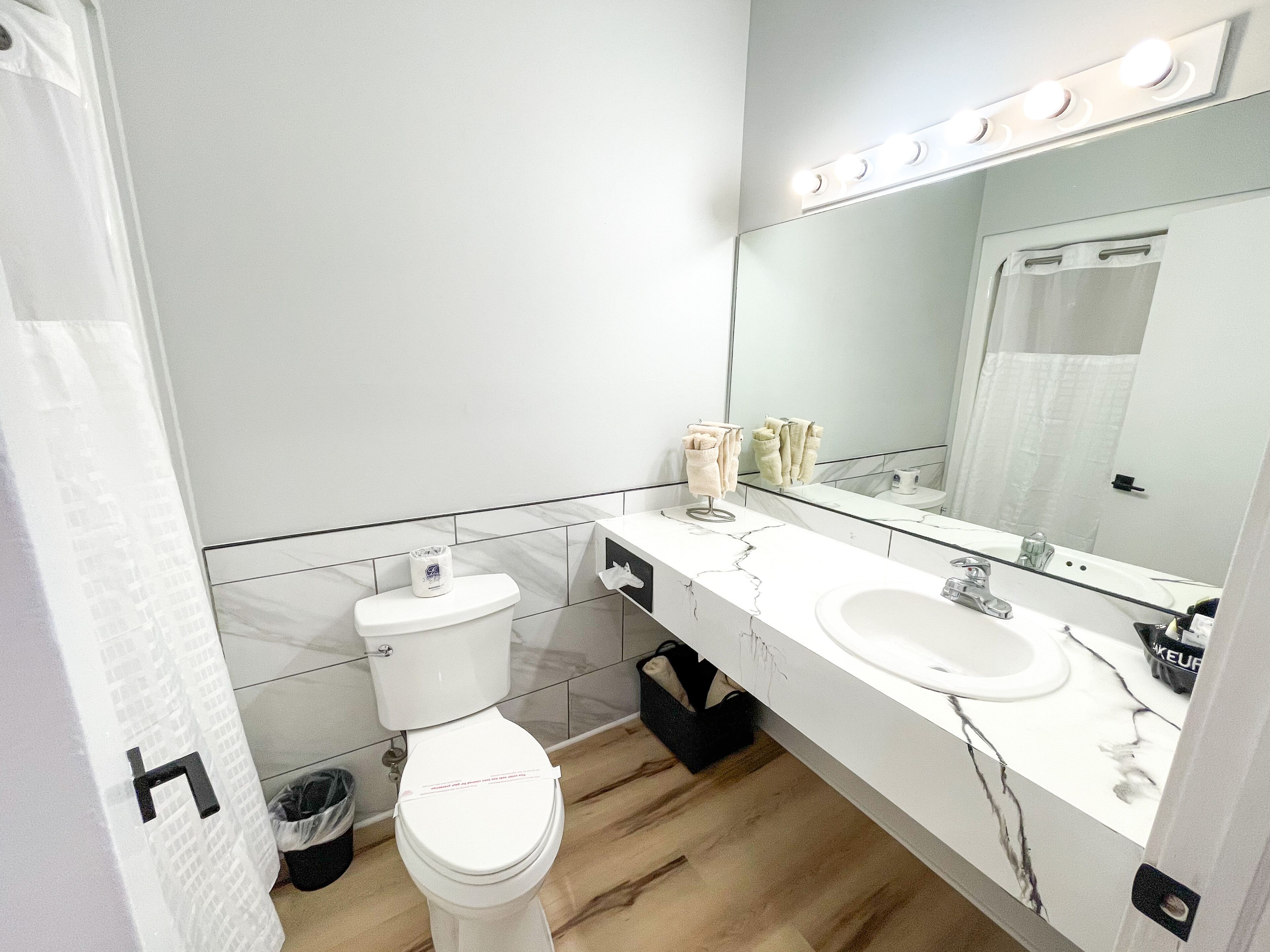 A modern bathroom with a toilet, sink, and mirror.