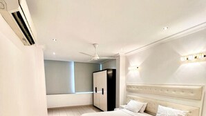 Een moderne slaapkamer met een groot bed, een nachtkastje, een kledingkast en een plafondventilator.