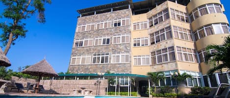 Alberca al aire libre, sombrillas en la alberca y camastros