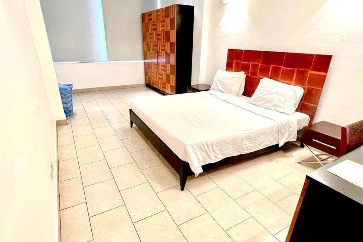 Une chambre à coucher avec un lit, une armoire et une table de chevet.