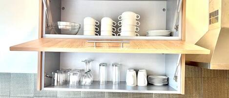 Une cuisine dotée d’un plan de travail en bois et d’une étagère intégrée.