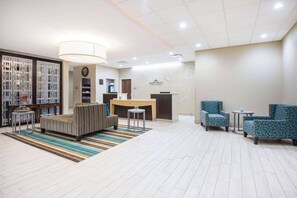 A hotel lobby with a reception desk, seating area, and a decorative wall. - Hawthorn Extended Stay by Wyndham Saint Clairsville (St. Clairsville)
