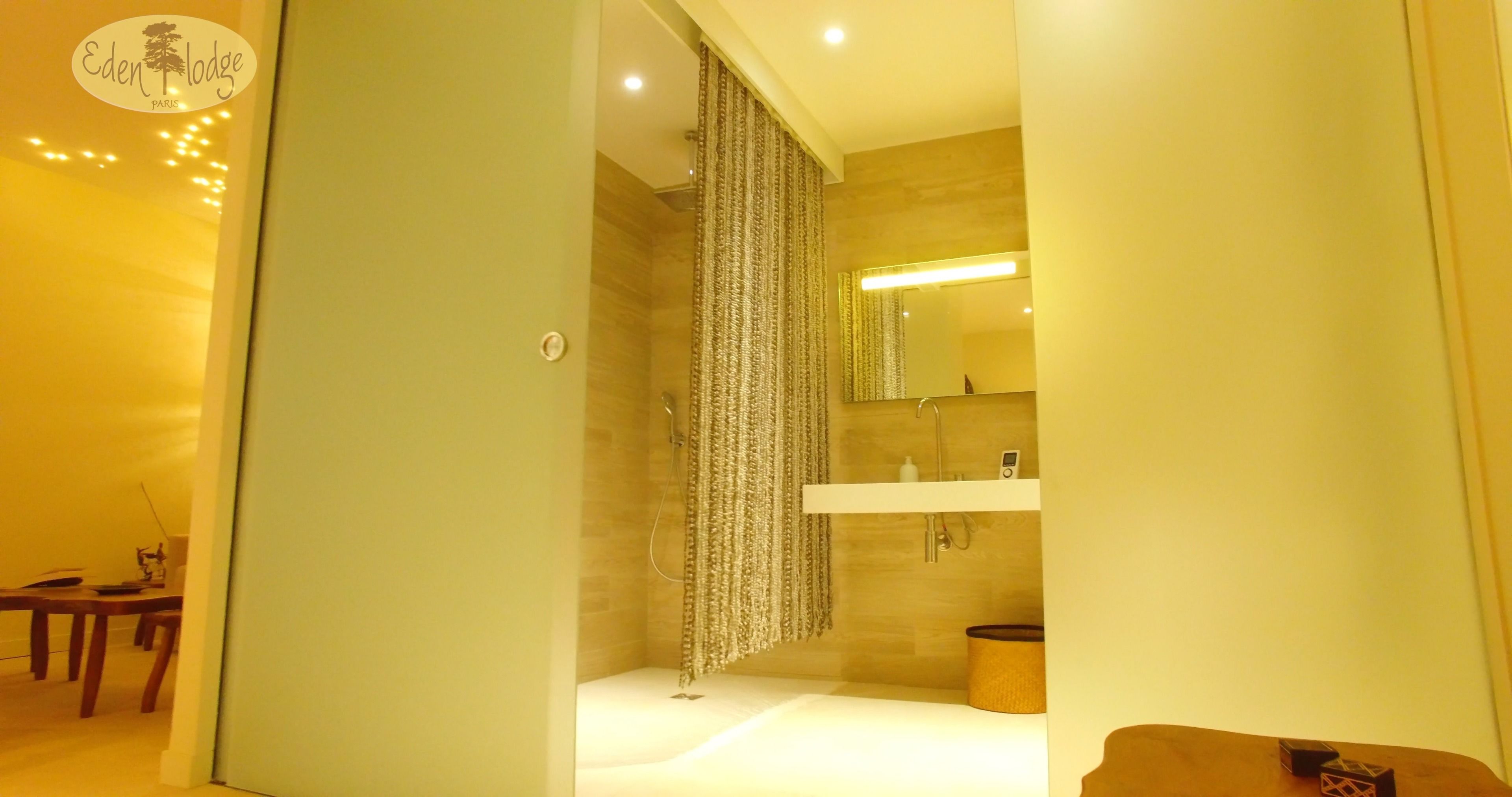 Un baño moderno con ducha, lavamanos y espejo.