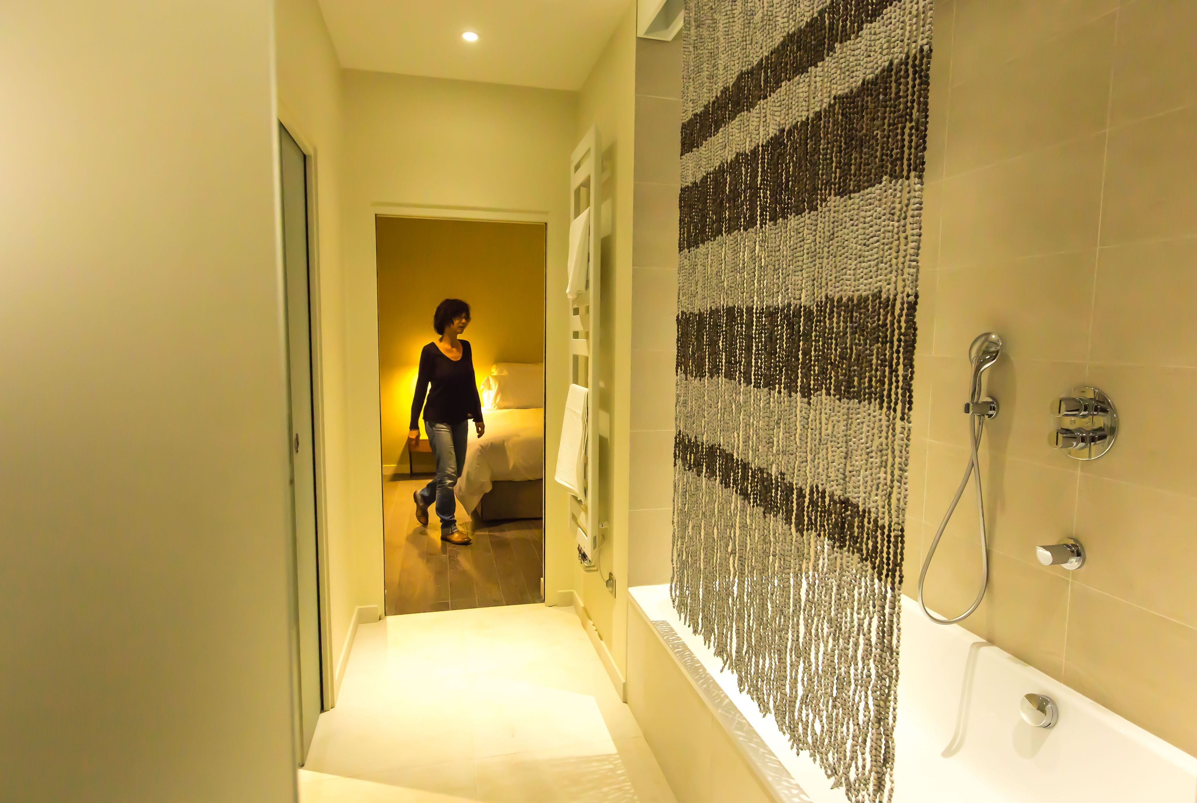 A hotel bathroom with a shower, a bathtub, and a towel rack.