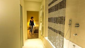 A hotel bathroom with a shower, a bathtub, and a towel rack.