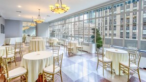 A spacious room with round tables and chairs, large windows, and a view of buildings. - 3 West Club (New York)
