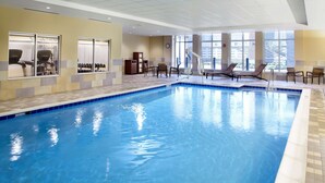 An indoor swimming pool with clear blue water, sunlit by large windows, surrounded by lounge chairs and exercise equipment. - Hyatt Place Cleveland/Lyndhurst/Legacy Village (Lyndhurst)
