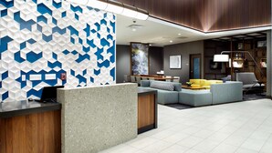 A modern lobby with a reception desk, seating area, and a staircase. - Hyatt Place Cleveland/Lyndhurst/Legacy Village (Lyndhurst)