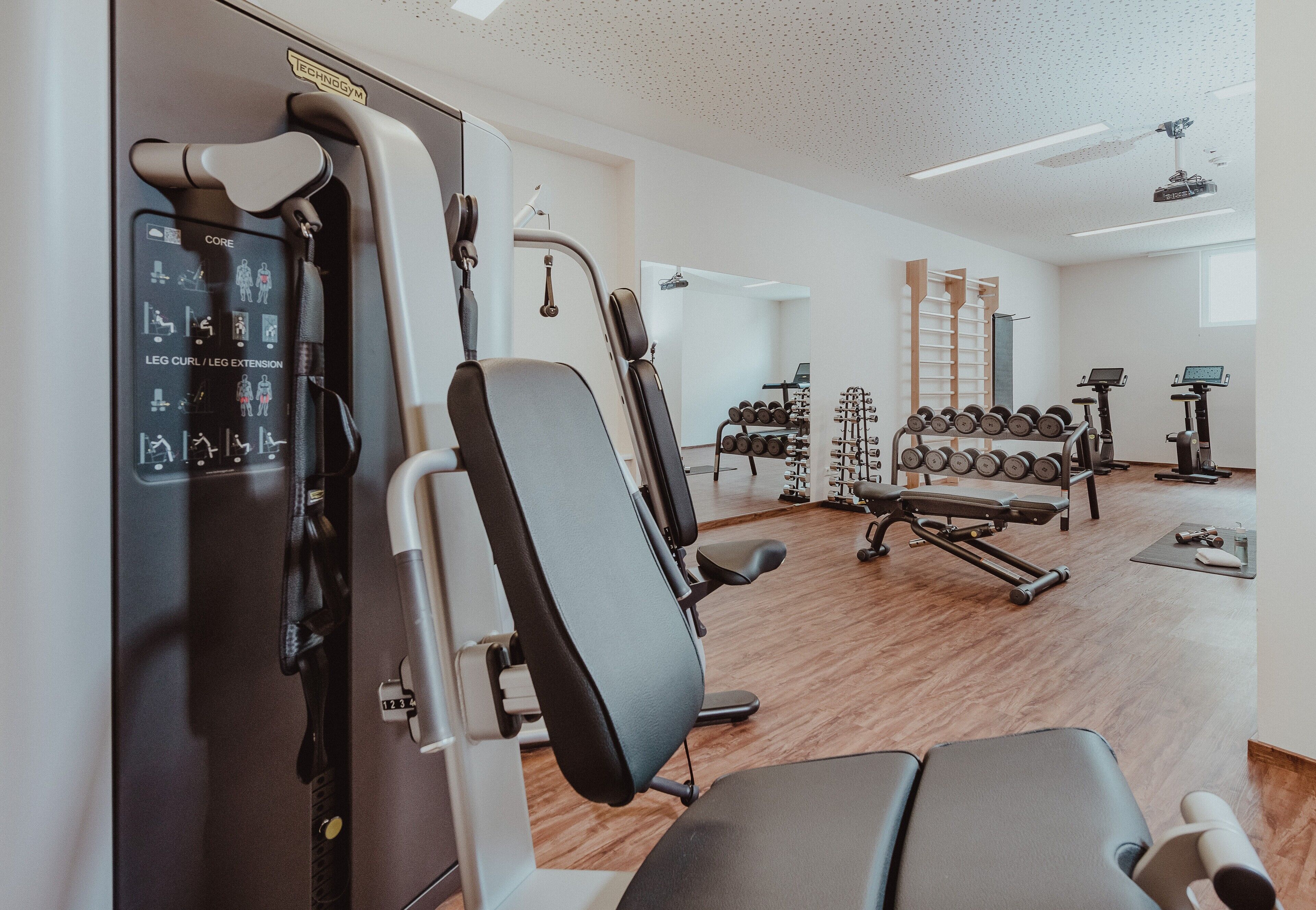 Un gimnasio con máquinas de ejercicio, pesas y equipo cardiovascular.