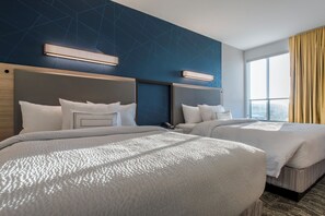 A hotel room with two beds, a modern design, and a large window offering a city view. - SpringHill Suites by Marriott Gallup (Gallup)