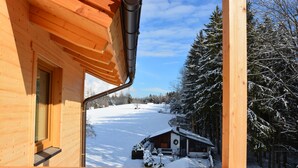 A wooden cabin with a snow-covered landscape and a clear sky. - Wirtshaus Nattererboden (Natters)