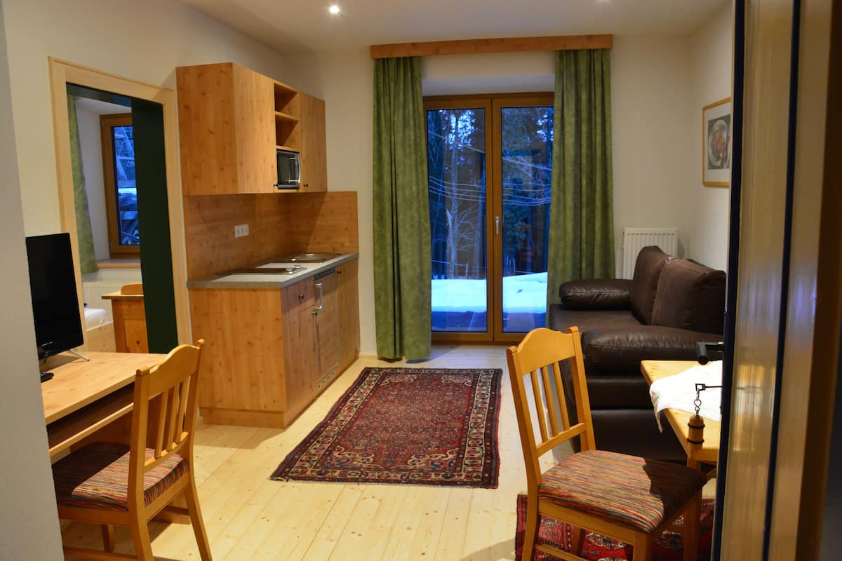 A compact living space with a kitchenette, dining area, and a sofa.
