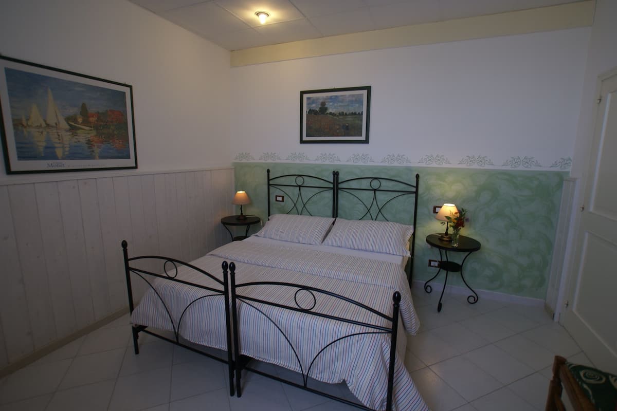Een slaapkamer met een bed, twee nachtkastjes en twee wandlampen.