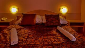 Ein Hotelzimmer mit einem Bett, zwei Nachttischen und zwei Wandlampen.