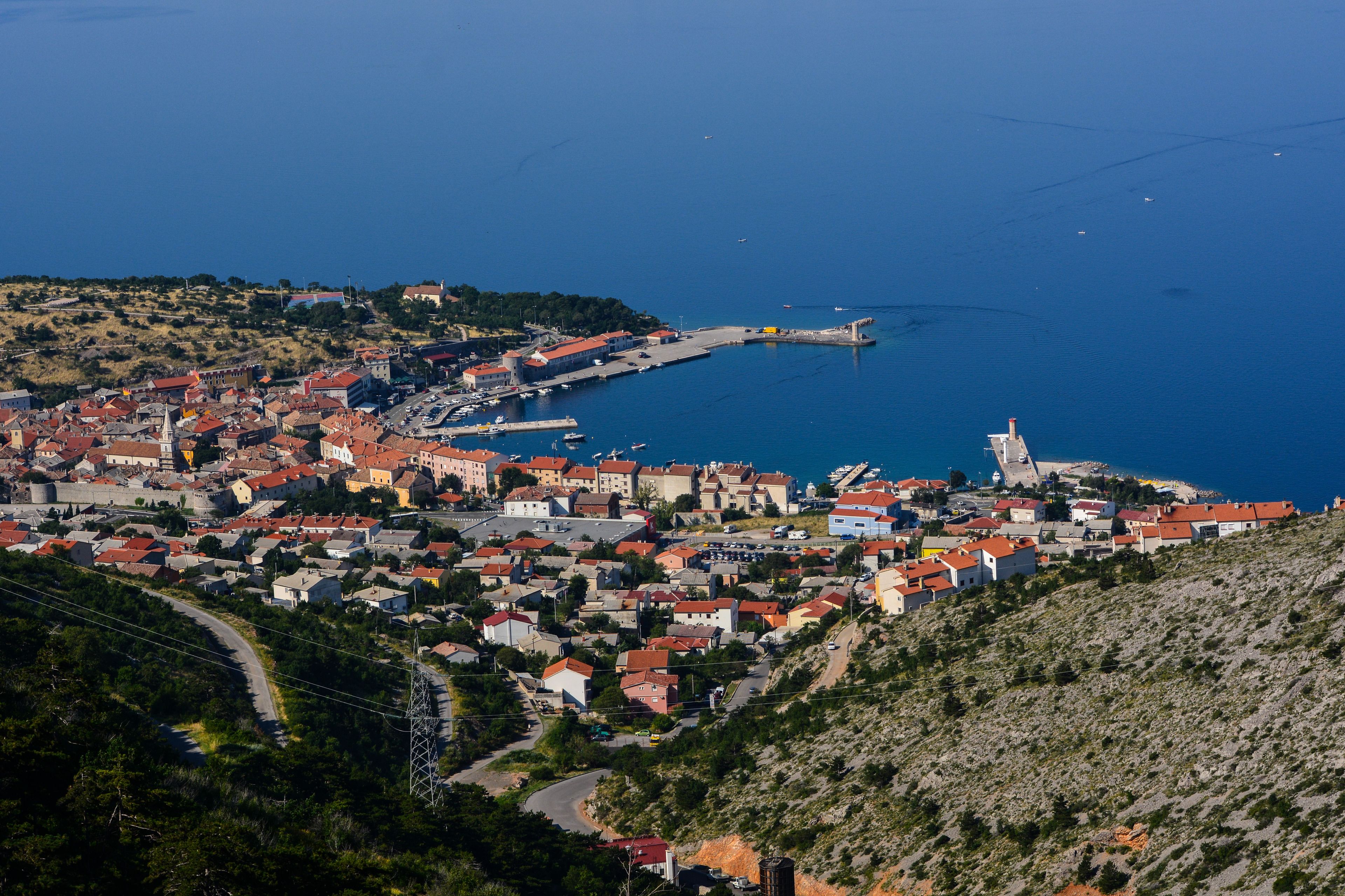 A coastal town with a marina, historic buildings, and a church.